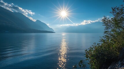 Wall Mural - lakeside view with sun glittering through morning mist and shimmering across the water
