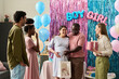 © pressmaster - Multiethnic Young Adults Celebrating Gender Reveal Party with Pregnant Woman Multiethnic group of young adults and middle aged man celebrating gender reveal party
