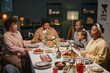 © Seventyfour - African American family with child holding hands and praying before enjoying festive meal in dining room