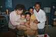 © Seventyfour - Portrait of happy multigenerational family gently embracing while posing at dinner table during mealtime gathering in living room, camera flash