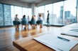 © Timofeeff - A modern conference room with large windows, featuring an empty table in the foreground adorned by documents