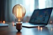 © miss irine - Bright light bulb near laptop. Idea of online learning education, remote work, e-learning from home concept. Digital technologies innovation, online business studying, knowledge, creativity.