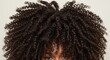 © Sanwa - Voluminous Curly Hair Texture - Close-up view of a woman's voluminous, dark brown curly hair. The curls are tight and well-defined