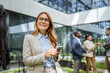 © Miljan Živković - Smart businesswoman use cellphone in front of modern office building