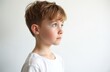 © Pete - Close-up of thoughtful boy looking away against white background. Blond caucasian kid is pensive, dreaming. Elementary student portrait. Childhood, youth, casual. Simple, clean photo for various uses.