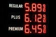 © whitestorm - Illuminated gas price sign displaying regular, plus, and premium gasoline prices, all exceeding $5.00 per gallon during a period of inflation.