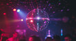 © SULTAN - A shiny disco ball hanging in a dark club with colorful lights and people in the background dancing