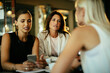 © Marko Geber - Diverse group of businesswomen having a meeting and enjoying coffee in a cafe bar in the city