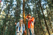 © ultramansk - Young Couple Resting Against Tree During a Winter Hike. Enjoying the Golden Hour Light in a Peaceful Forest, Wearing Warm Clothes and Backpacks, Sharing a Quiet and Happy Moment Together