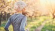© Zheng - Strong cancer survivor woman jogging in spring park wearing headscarf, surrounded by beautiful cherry blossoms. Resilience, hope and overcoming adversity concept.