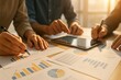 © Sakiyah - Collaborative Team Analyzing Financial Data Charts and Graphs in Modern Office Environment