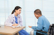 © Rakchanok - Female doctor consulting senior patient across table, pointing at laptop screen while discussing treatment plan in professional and friendly healthcare environment, illness, hospitality.