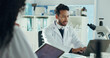 © peopleimages.com - Man, scientist and laptop in lab with colleague for microbiology study, report or feedback with discussion. Team, microscope and talking for medical research, pharmaceutical development and typing