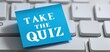 © anstam - The sticky note urging you to take the quiz in a modern workspace.