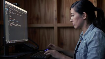 Focused cybersecurity expert designing an application software at her workspace