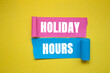 © Emre Akkoyun - Holiday hours message written on ripped torn color paper pieces on yellow background. Conceptual holiday hours symbol. copy space.