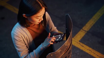 Futuristic shield design interface showcased on mobile display by Asian woman
