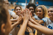 © Ольга Щербакова - Team of female volleyball players celebrating their victory with a high five in a sports arena during a tournament event