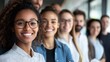 © Khan - A diverse group of people standing in a row, smiling and looking at the camera.