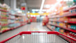 © Alexander - Shopping cart in supermarket aisle with colorful products on shelves, bright lighting and wide space, illustrating retail shopping and consumer choice indoors.