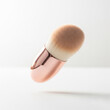 © MrIdhA - Floating oval makeup brush with rose gold ferrule on a solid white background