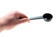 © dimas830 - Adult hand holding plastic coffee scoop for espresso machine dosing