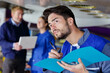 © auremar - handsome young auto mechanic in uniform is holding a folder