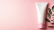 © svastix - A sleek white cosmetic tube nestled beside fresh leaves on a pink backdrop, representing beauty and nature's harmony in skincare products for a luxurious experience.
