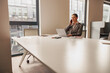 © Yaroslav Astakhov - A dedicated businesswoman is making an important call while efficiently working on her laptop in a modern office