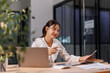 © David - Young business Asian woman working on a laptop computer in a office,doing finances, accounting analysis, report data pointing graph Freelance education and technology concept.
