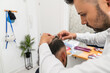 © Koldo_Studio - Hair clinic specialist attaching hair replacement system to client, offering solution for hair loss and boosting self confidence