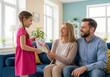 © Minnoc  - family sitting on sofa and watching tv