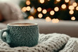 © Karuna - Cozy nook with serene holiday vibes featuring steaming cup of coffee on knitted blanket, surrounded by soft bokeh lights from Christmas tree
