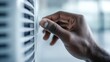 © Larisa AI - A close-up view of a hand adjusting the temperature control on an air conditioner, emphasizing comfort and control in a modern living space during warm weather.