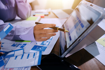 Close up ux developer and ui designer brainstorming about mobile app interface wireframe design on table with customer breif and color code at modern office.Creative digital development agency.