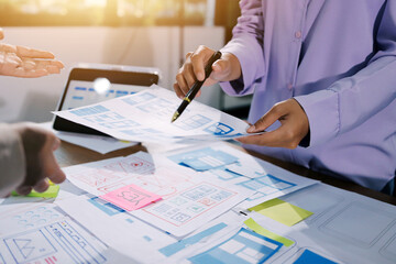 close up ux developer and ui designer brainstorming about mobile app interface wireframe design on t