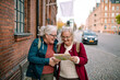 © Davor - Senior women laughing while reading city map on vacation