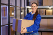 © Pixel-Shot - Female worker with parcel box in warehouse
