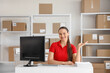 © Pixel-Shot - Female worker sitting at table in warehouse