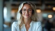 © Larisa AI - A smiling woman in a professional setting wears headphones while working, showcasing a moment of focus and joy in her modern workspace filled with natural light.