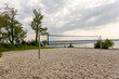 © Evgeniia - Beach volleyball court with sand, net, green lawn, and lake on background. Summer sport concept, outdoor recreation area, active lifestyle