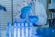 © kamiphotos - a female chemist is testing various liquid compounds in a lab, a scientist is doing research on the development of science in a lab, laboratory, test tube, scientific