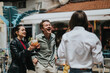 © qunica.com - Friends sharing moments outdoors in a lively setting, expressing fun, happiness, and camaraderie. They are enjoying beverages and smiles, depicting the joy of social connections with warm emotions.