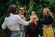 © qunica.com - Friends toasting with cocktails in a vibrant outdoor setting, celebrating togetherness and cheerful moments in a natural green surrounding, showcasing a relaxed atmosphere for fun and socialization.