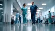 © ryker - Busy hospital interior with healthcare professionals walking through corridor, showcasing dynamic environment filled with activity and care. blurred background emphasizes focus on staff