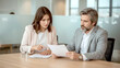 © Ada - Two professional executives discussing financial accounting papers working together in office. Mature business woman manager consulting older man client holding legal documents