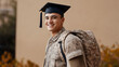 © Carmen - Smiling and confident young Hispanic man wearing camouflage uniform and graduation cap, GI Bill education concept