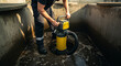 © Photo Dogg - Worker Using Submersible Pump in Industrial Setting
