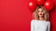 © svastix - A young woman poses with red balloons in front of a vibrant red backdrop, conveying a sense of joy and celebration through her expressive look and playful accessory.