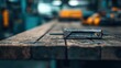 © svastix - A close-up view of a rusty metallic tool placed on a weathered wooden table, showcasing its age and the craftsmanship of industrial design in a workshop environment.